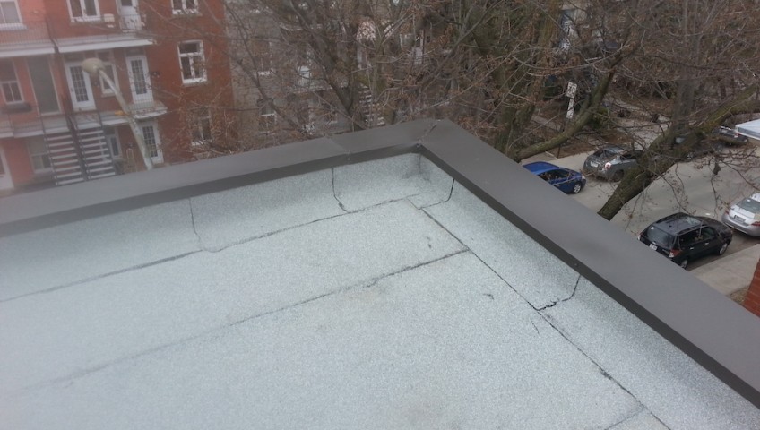 Exterior view of a flat roof of a building showing the end result of a professional waterproof roofing